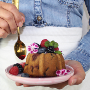 Mujer con un bizcocho de frutas una receta nutritiva.